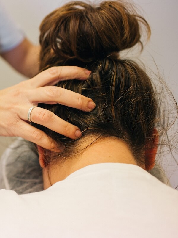 Close-up of Indian head massage, Gemma's hands working through a client's hair at the nape of the neck