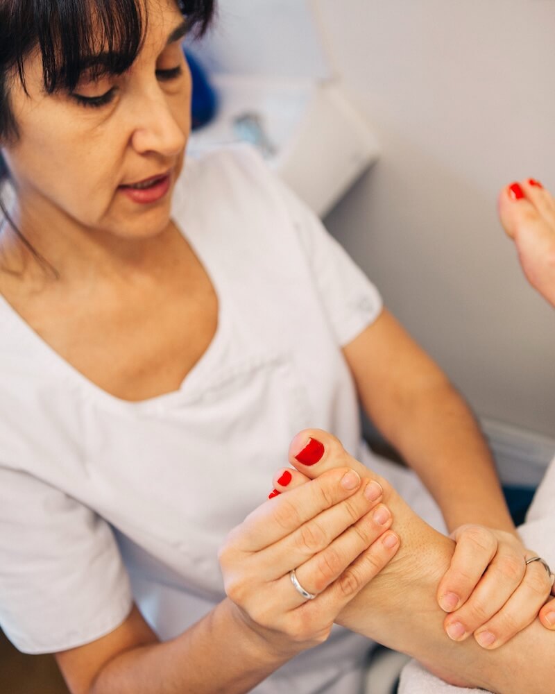 Gemma Avila performing reflexology on a client's foot in her treatment room
